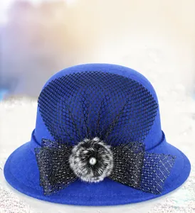 Detail of wool cloche hat with blue finish, mesh veil, and pearl embellishment
