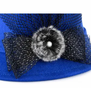 Detailed shot of blue wool hat featuring a mesh bow, faux fur pompom, and pearl accents