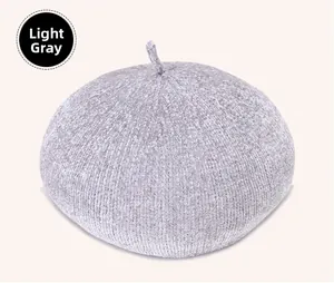 Detailed texture of light grey knitted beret hat showing soft chenille fabric and stem top