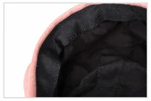 Detail of the pink wool beret showing the black mesh sweatband and interior lining