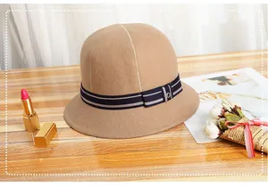 Detail van camel wollen cloche hoed met gestreept lint en strik op houten tafel