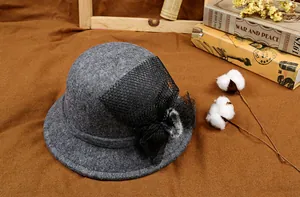 Detail of wool cloche hat with mesh bow, plush ball decoration and vintage props