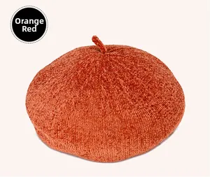 Detailed view of the soft knitted texture and orange red fabric of the beret hat