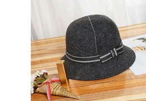 Primo piano di cappello cloche in feltro grigio scuro con fascia a righe