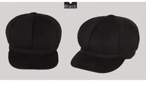 Detail view of black octagonal newsboy hat with textured fabric and top button