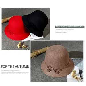 Close-up of three wool cloche hats in red, black and camel with bow details for autumn