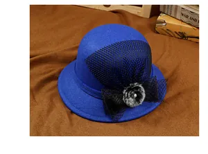Close-up of royal blue wool cloche hat with mesh bow, plush ball, and pearl detail