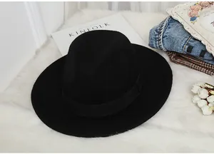 Close-up of a classic black wool fedora hat with a ribbed ribbon on a stylish plush background