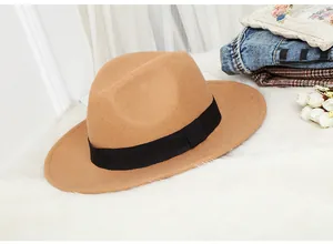 Close-up of camel wool felt fedora hat featuring black grosgrain ribbon on white fur
