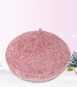 Close-up of pink knit beret with soft chenille texture and top loop detail in snow scene