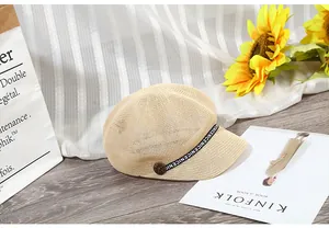 Dettaglio cappello newsboy in paglia beige con fascia 'NICE' e bottone laterale vintage