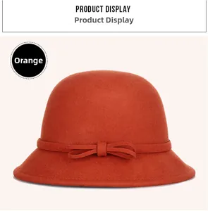 Detail of orange wool cloche hat showing fine felt texture and elegant bow ribbon