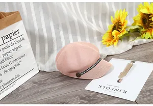 Dettaglio di un berretto estivo rosa in mesh con nastro NICE e bottone vintage