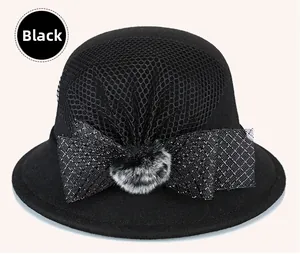 Detail of black wool cloche hat featuring mesh veil and faux fur pom-pom bow decoration