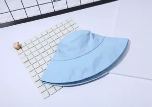 Λεπτομέρεια από γαλάζιο βαμβακερό καπέλο bucket με λευκό κέντημα RABERAND και ραμμένο γείσο