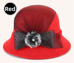 Close-up of red wool cloche hat with black mesh veil, checkered bow and pearl detail