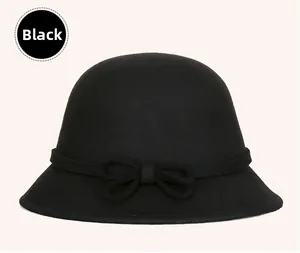 Close-up of elegant black wool cloche hat featuring a delicate bow and thick texture