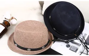 Nahaufnahme von Wollhüten mit Lederband, Metallnieten und Quasten für den Herbst