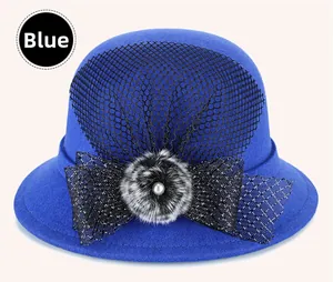 Detailed view of blue wool cloche hat with black mesh veil and pearl embellishment