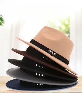 Stack of wool felt fedora hats in various colors with rivet belt detail on wooden surface