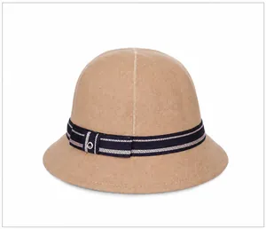 Dettaglio di un cappello cloche in feltro kaki con nastro a righe blu e occhiello in metallo