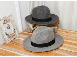 Detail of dark and light grey wool fedora hats with black decorative bands on books