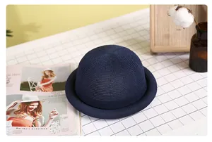 Close-up of a navy blue straw woven dome hat with elegant curled brim and mesh texture