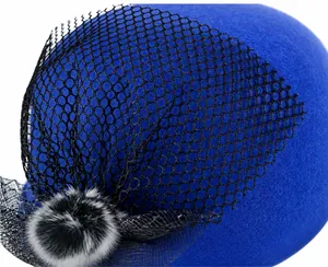 Detail of wool cloche hat with black honeycomb veil and plush faux fur decoration