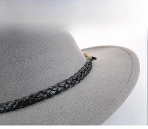 Detail of grey wool fedora hat featuring woven leather band and vintage metal buckle