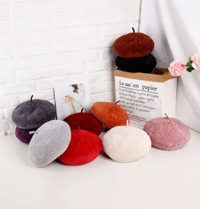 Detailed knit texture of four autumn beret hats in brown, black, and purple shades