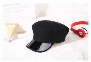 Dettaglio del cappello da marinaio nero con visiera in pelle verniciata lucida e lana