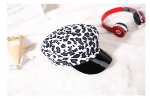 Dettaglio cappello stile报童 con stampa leopardata e visiera nera lucida su fondo