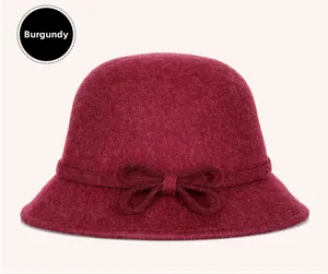 Close-up of purple red wool felt hat with bow decoration and elegant curved brim
