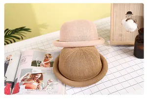 Detail of elegant straw bowler hats in pink and khaki colors for summer fashion