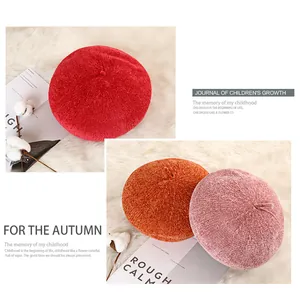 Flat lay of colorful thick knit berets on white faux fur with autumn decor details