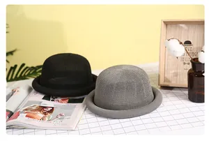 Close-up of elegant black and grey breathable straw knit cloche hats on a plaid cloth