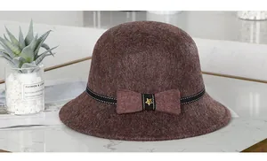 Detail eines rotbraunen Wollfilzhuts mit schwarzem Polka-Dot-Band und goldenem Sternanhänger