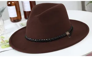 Detail of a brown wool fedora with a black woven band and a gold shield buckle
