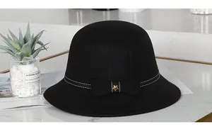 Detailaufnahme von schwarzem Filzhut mit gestreifter Schleife und goldenem Stern