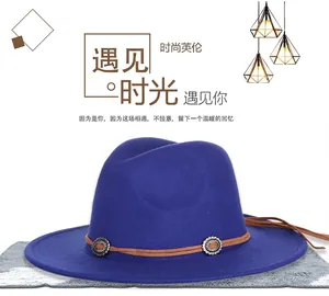 Detail of blue wool fedora hat featuring brown leather band and metallic buckle accents