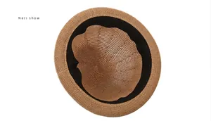 Detail view of woven straw sun hat interior with black sweatband and fine texture