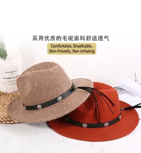 Detail of wool fedora hat featuring a vintage metal buckle, leather band and black tassels