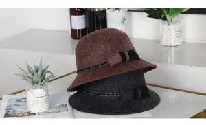 Nahaufnahme von Wollglockenhüten in Rotbraun und Dunkelgrau mit elegantem Schleifendetail