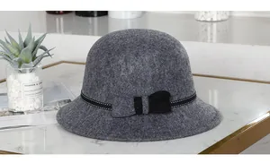 Detailansicht eines dunkelgrauen Wollfilzhutes mit gepunktetem Schleifenband und Schleife