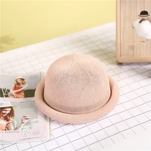 Elegant beige straw dome hat with rolled brim for women in a stylish setting