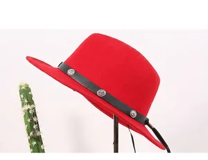Detail of red wool felt fedora featuring a black leather band and silver embossed buckles