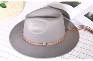 Detail view of a gray wool fedora with a vintage ethnic metal studded leather band
