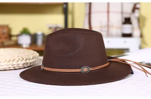 Detail of dark brown fedora wool hat featuring a leather band with metal ornament