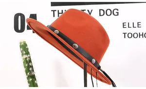 Detail of orange wool fedora featuring a black leather band and antique metal buckles