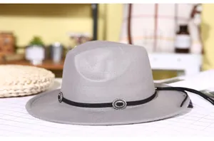 Detail of grey wool fedora hat with black band and silver embossed metal buckle decoration